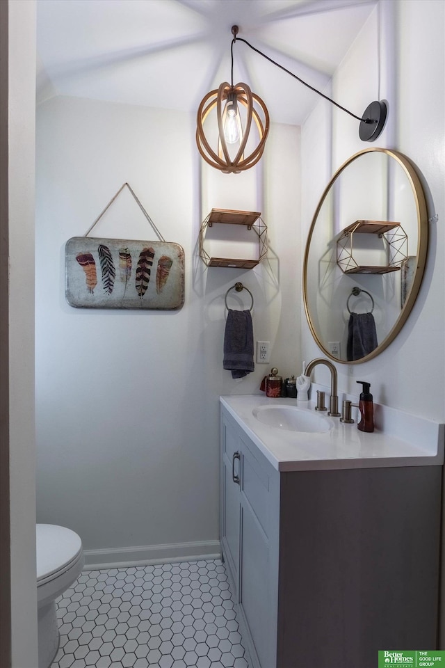 bathroom with vanity, toilet, baseboards, and tile patterned flooring