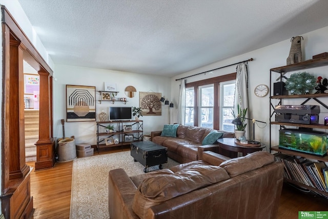 living area with a textured ceiling and wood finished floors