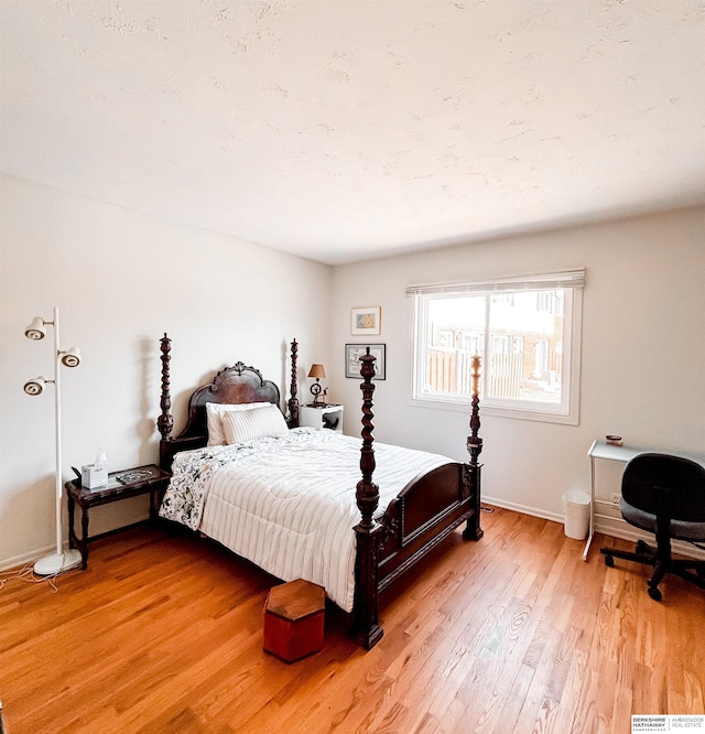 bedroom with light wood finished floors and baseboards