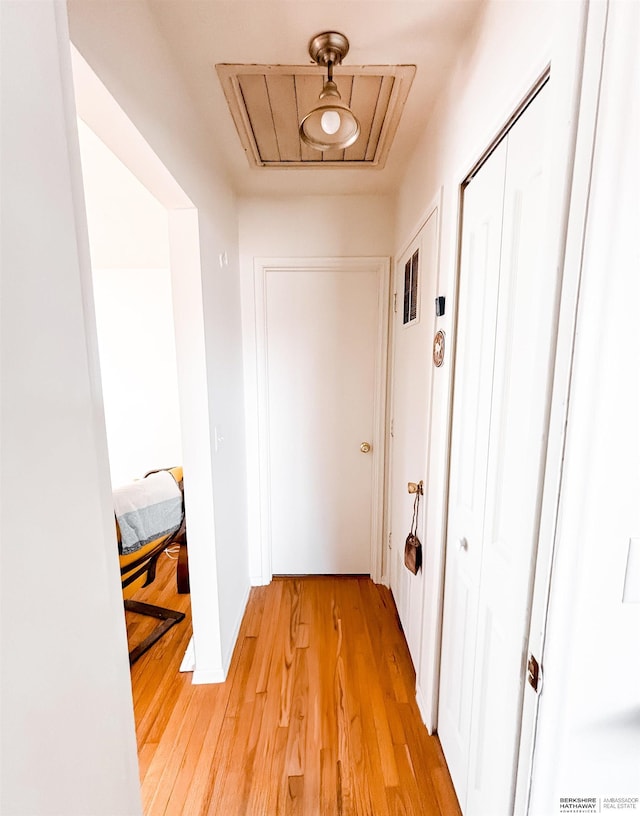 hallway featuring attic access and light wood-style flooring