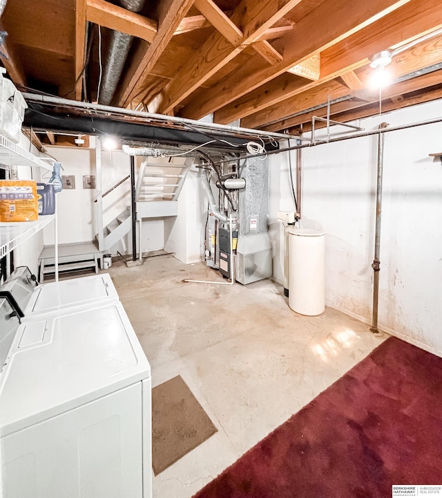 unfinished basement featuring heating unit, stairs, and washing machine and clothes dryer