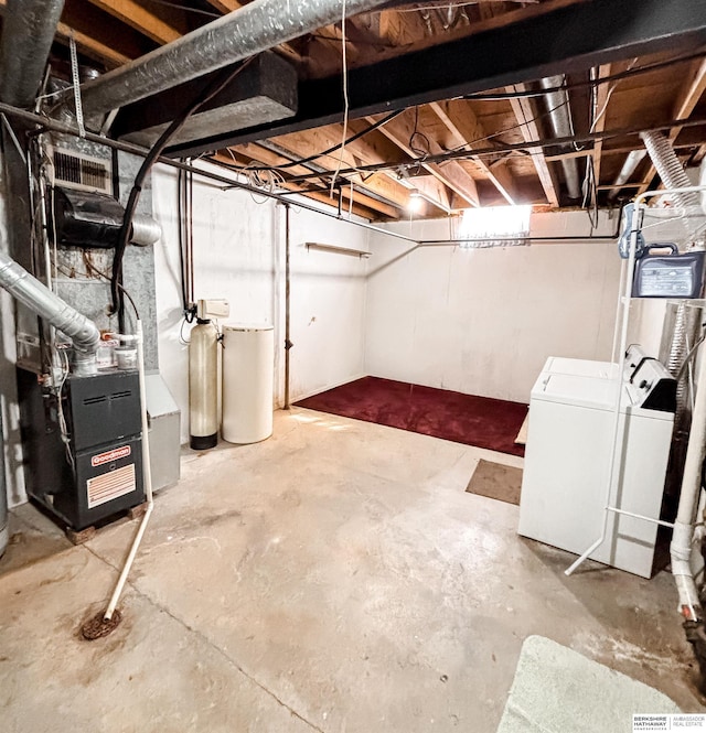 unfinished basement with heating unit and separate washer and dryer