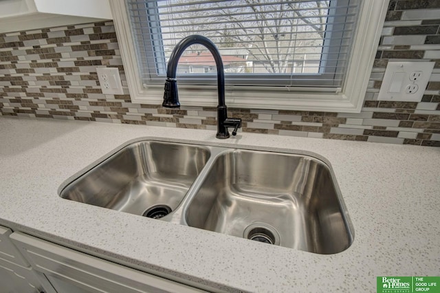 details featuring a sink, decorative backsplash, and light stone countertops