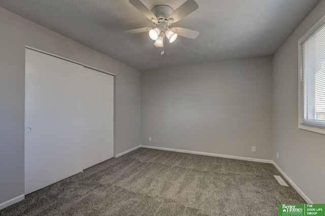 unfurnished bedroom with visible vents, a ceiling fan, a textured ceiling, carpet floors, and baseboards