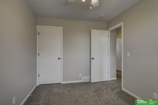 unfurnished bedroom featuring visible vents, carpet floors, a textured ceiling, and baseboards