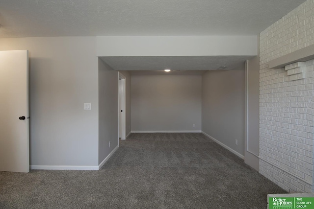 carpeted spare room with a textured ceiling and baseboards