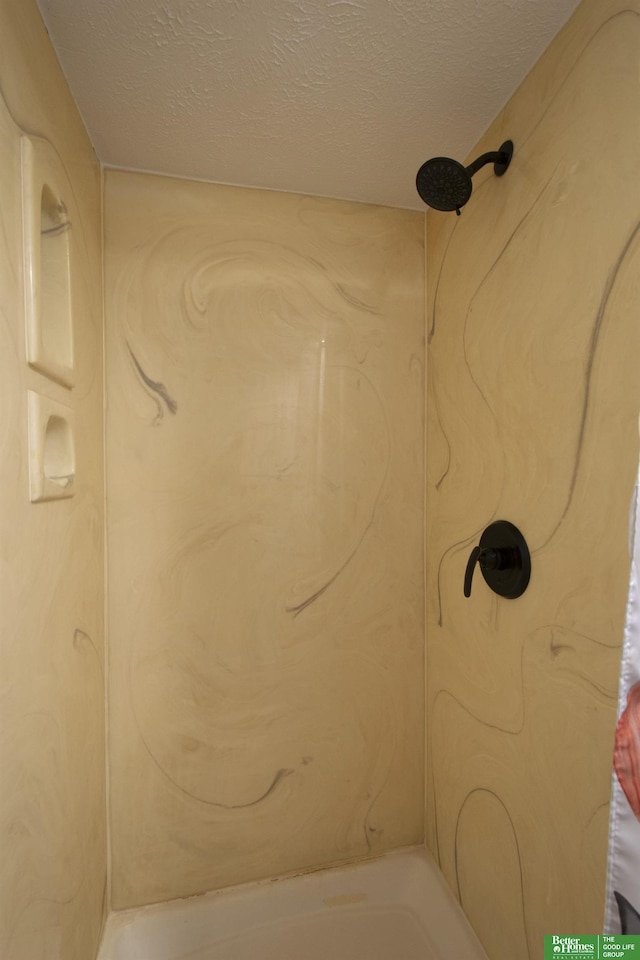 bathroom featuring a textured ceiling and walk in shower