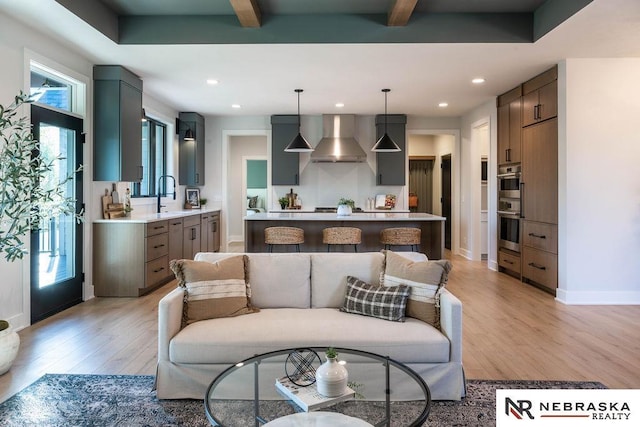 living room featuring recessed lighting, beamed ceiling, and light wood-style floors