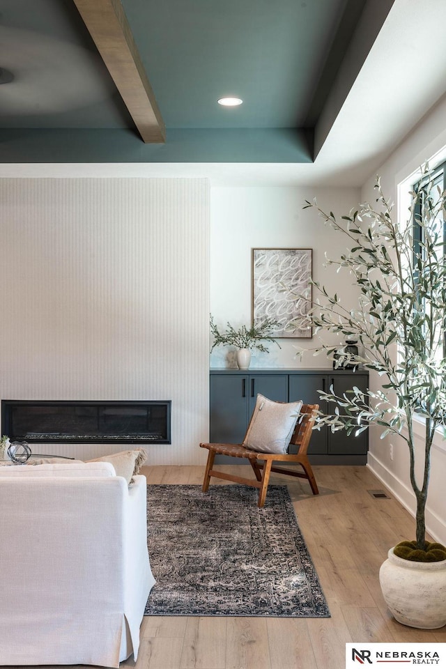 living area with baseboards, wood finished floors, and a fireplace