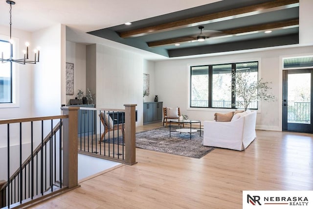 living room with wood finished floors, baseboards, recessed lighting, beamed ceiling, and ceiling fan with notable chandelier