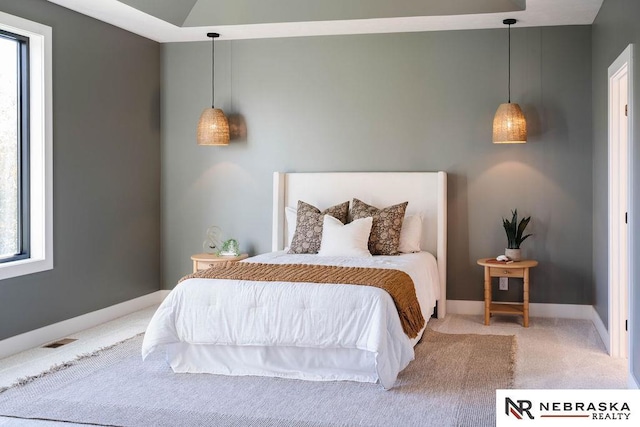 carpeted bedroom featuring multiple windows, baseboards, and visible vents