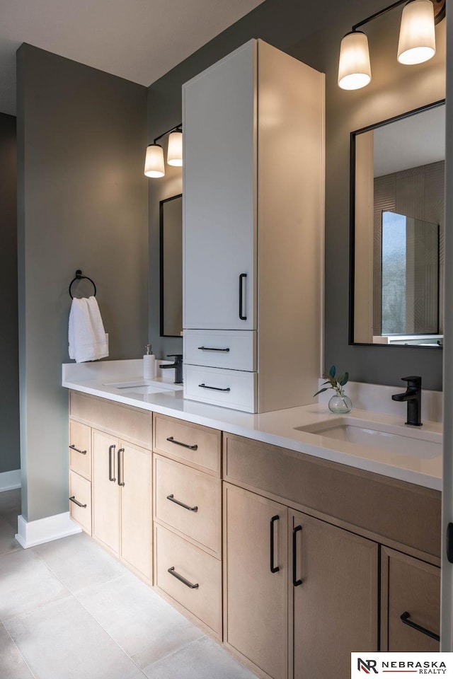 full bathroom featuring a sink, double vanity, and tile patterned flooring