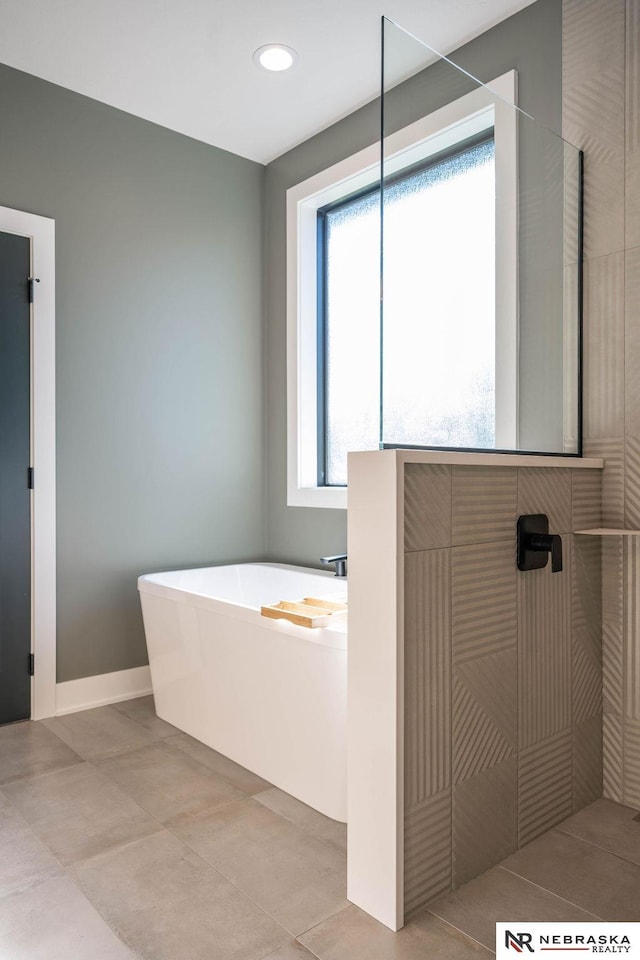 full bath featuring a tile shower, a soaking tub, tile patterned floors, and baseboards