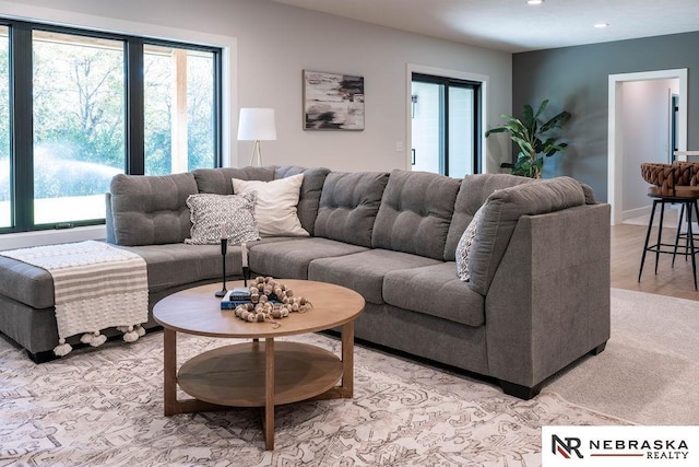 living area featuring light wood-style flooring, plenty of natural light, recessed lighting, and baseboards