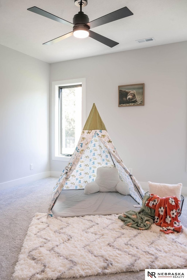 playroom featuring visible vents, baseboards, ceiling fan, and carpet flooring