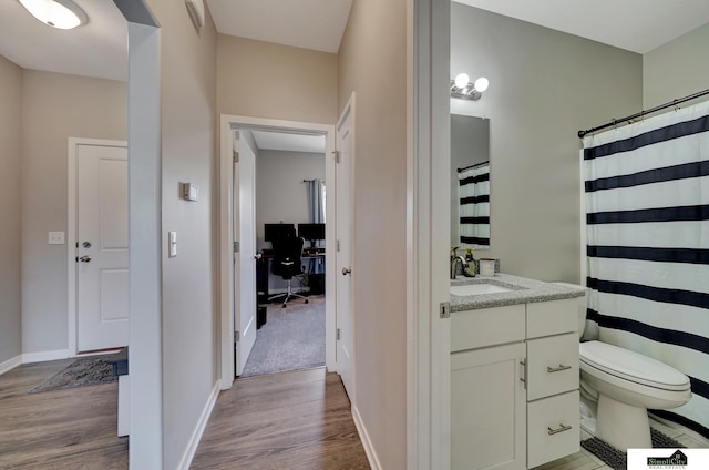 full bath featuring baseboards, toilet, wood finished floors, and vanity