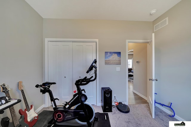 exercise area featuring visible vents, carpet floors, and baseboards