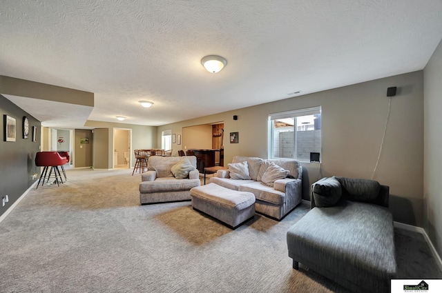 living room featuring visible vents, light colored carpet, a textured ceiling, and baseboards