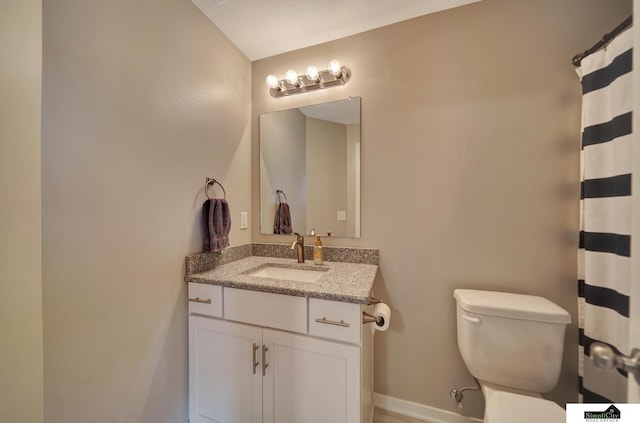 full bath with vanity, toilet, and baseboards