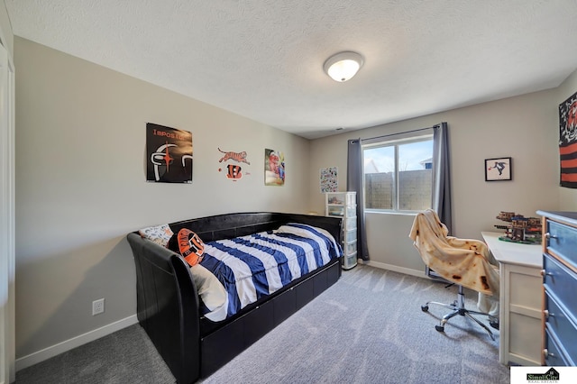 carpeted bedroom with baseboards and a textured ceiling