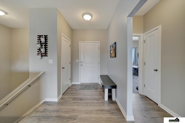 foyer entrance with visible vents, baseboards, and wood finished floors