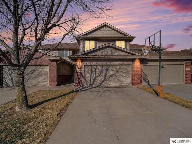 view of front facade with a garage, brick siding, and driveway