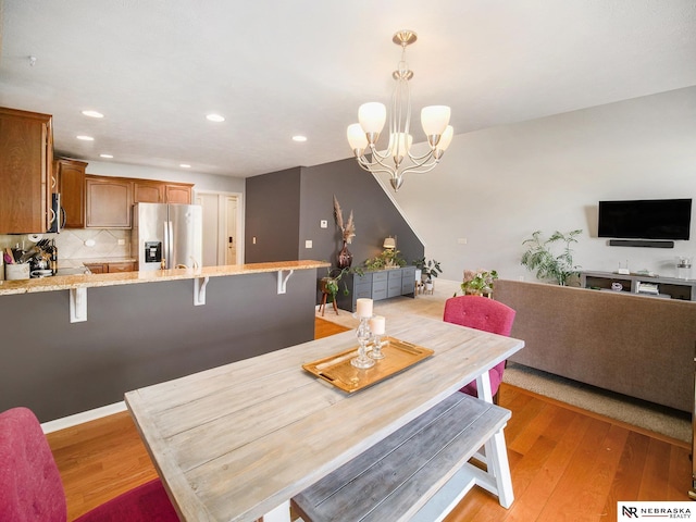 dining space with an inviting chandelier, recessed lighting, and light wood-style floors