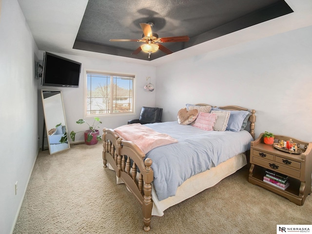 bedroom featuring baseboards, a raised ceiling, ceiling fan, and carpet flooring