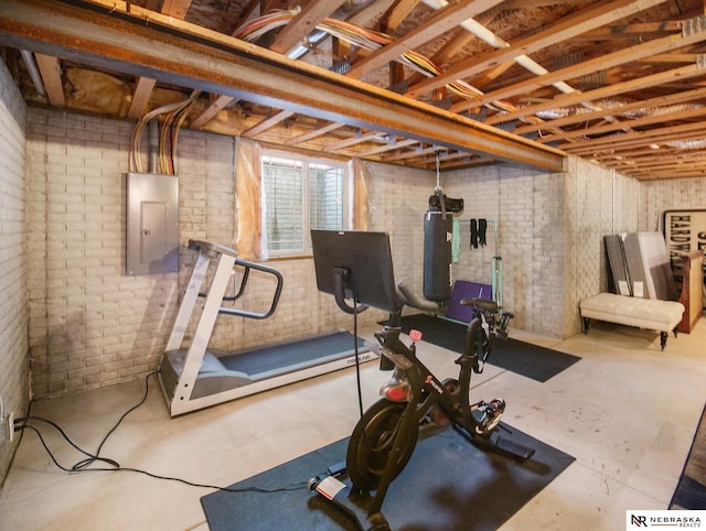 exercise room with electric panel and brick wall