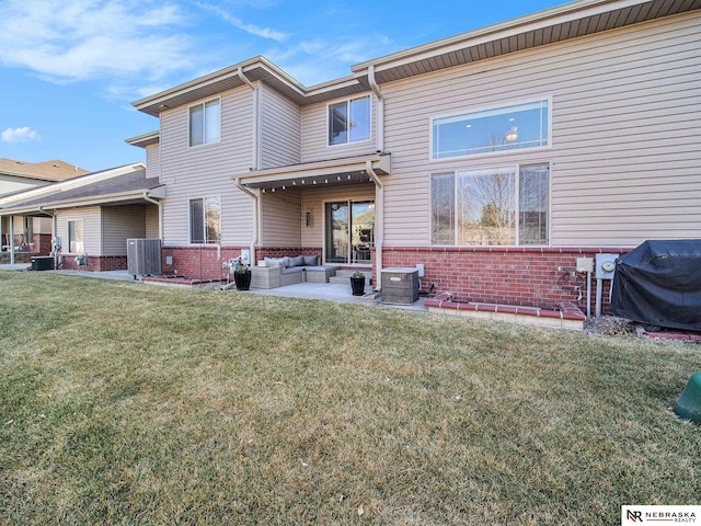 back of property with a yard, an outdoor hangout area, brick siding, and central air condition unit