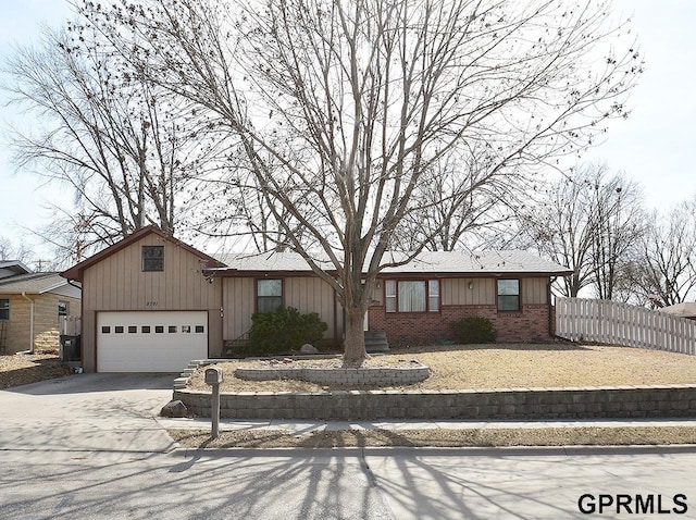 view of front of house with fence, board and batten siding, concrete driveway, an attached garage, and brick siding