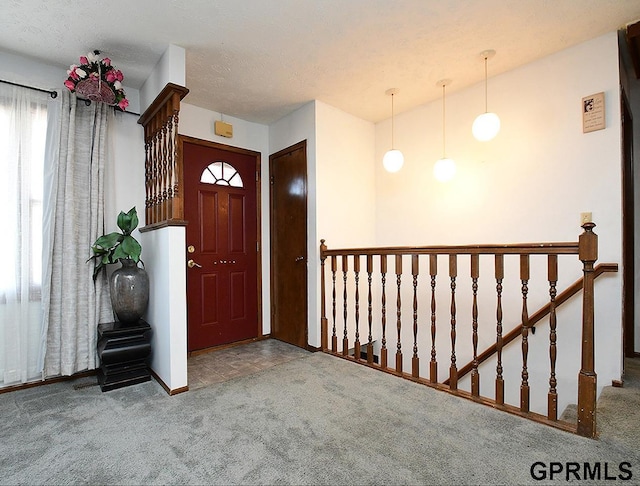 carpeted entrance foyer with a textured ceiling