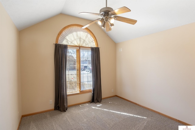 empty room featuring visible vents, carpet, baseboards, ceiling fan, and vaulted ceiling