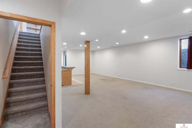 basement featuring stairway, recessed lighting, light colored carpet, and baseboards