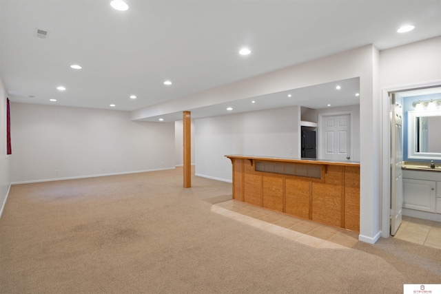 interior space featuring visible vents, indoor bar, light colored carpet, recessed lighting, and a sink