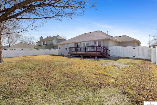 rear view of property with a yard, a wooden deck, a fenced backyard, and a gate