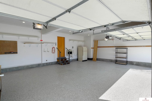 garage featuring a garage door opener and freestanding refrigerator