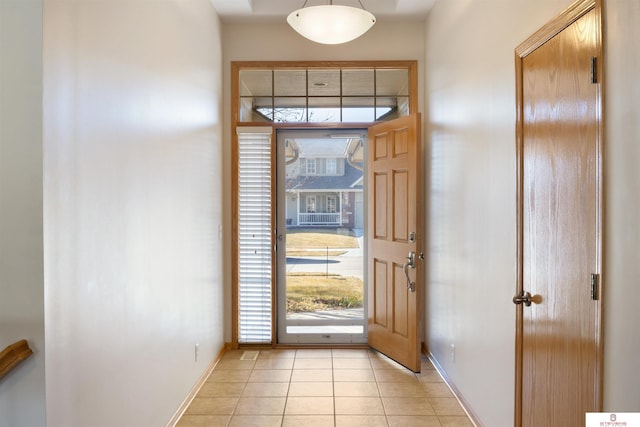 foyer entrance featuring light tile patterned floors and baseboards