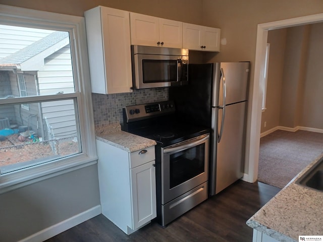 kitchen featuring baseboards, decorative backsplash, dark wood-type flooring, appliances with stainless steel finishes, and white cabinetry