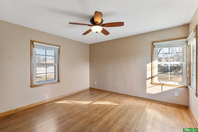 spare room featuring baseboards, light wood-style floors, and ceiling fan