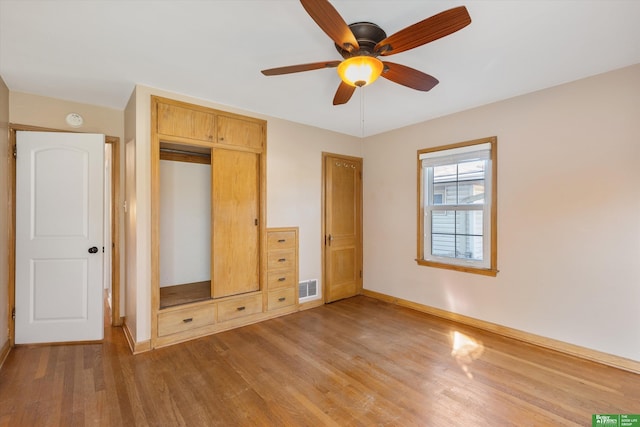 unfurnished bedroom with visible vents, baseboards, wood finished floors, a closet, and a ceiling fan