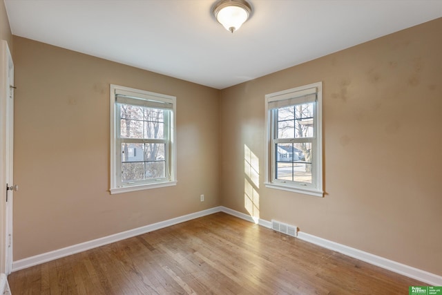 empty room with visible vents, baseboards, and light wood-style floors