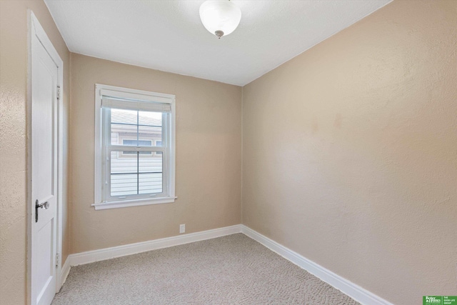 empty room featuring baseboards and light colored carpet