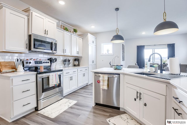 kitchen with decorative backsplash, light countertops, a wealth of natural light, and appliances with stainless steel finishes