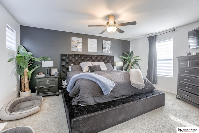 bedroom featuring light carpet, baseboards, and a ceiling fan