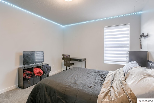 bedroom with baseboards and carpet