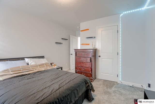 bedroom featuring baseboards and light carpet