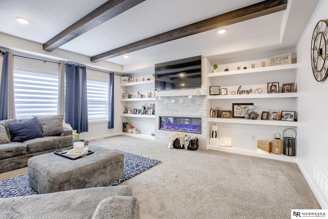 carpeted living area featuring beam ceiling, built in shelves, a fireplace, and baseboards