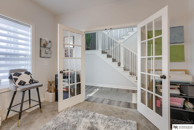 interior space featuring wood finished floors, french doors, and baseboards