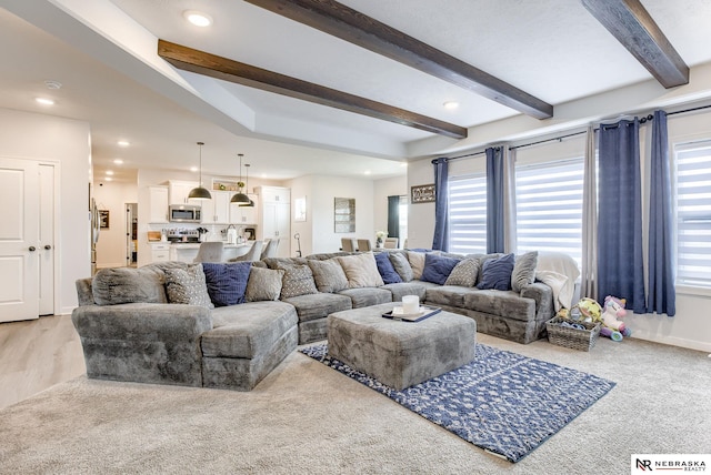 living area featuring recessed lighting, baseboards, and beam ceiling